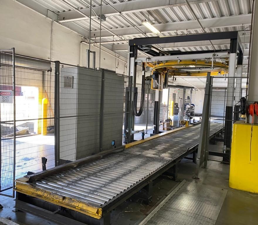 Ring stretch wrapper with roller conveyor